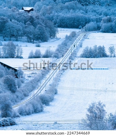 Train line pasing through a snowy landscape in winter.