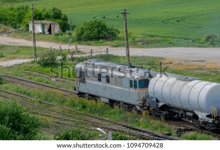 Train locomotive leaving station with petroleum tanks