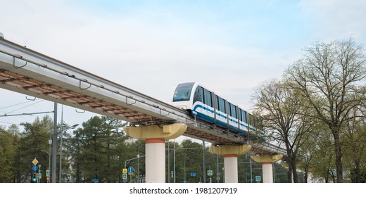 Train Moving Along The Rails Over The Bridge Over The City. Surface Metro. Modern Public Urban Transport. Railroad Tracks Above The Ground