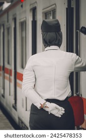 Train officer standing beside train while train stop at the train station