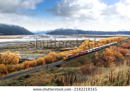 train on the railroad with mountain and blue sky background in autumn season newzealand