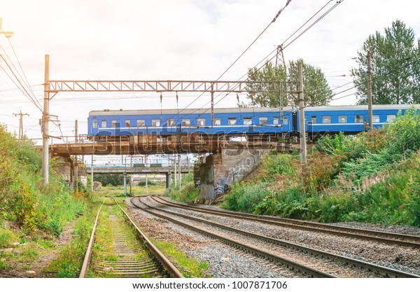 Train a passenger car drives along a railroad\
bridge through a friend\
railway
