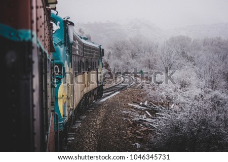 Train passenger perspective of the winding Verde Canyon Railroad with snow covering the trees and rock formations of Verde Canyon, near Perkinsville, Arizona