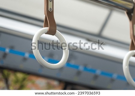 Train passenger standing handle hook on the railing bar, using to gripping for stable. Transportation equipment object photo, selective focus.