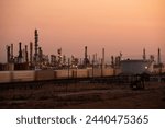 A train passes by an oil refinery at sunset in Bakersfield, California, USA.