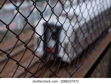 The Train Passes Outside The Fence Or Bluur Kereta Api Milik PT KAI (Kereta Api Indonesia) Lewat Di Atas Rel Dengan Foto Blur