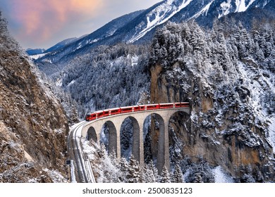 Train passes through snow-capped mountains in Filisur, Switzerland in the winter of the Swiss Alps. - Powered by Shutterstock