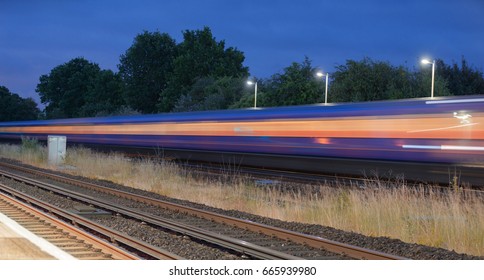 Train Passing Through A UK Station At High Speed Captured As Motion Blur