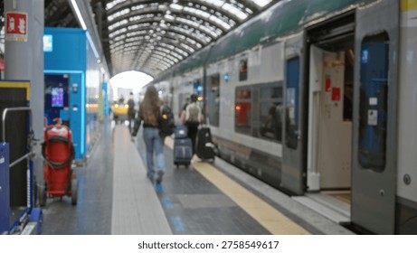 Train platform defocused background with soft bokeh, blurred luggage and open carriage under arched roof; background copyspace backplate calm.