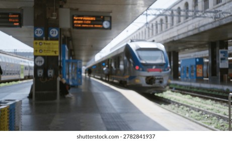 Train platform scene in soft defocused bokeh with blurred trains, tracks and station architecture; background backdrop copyspace backplate.