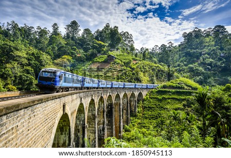Train ride over mountain railway bridge on green nature landscape