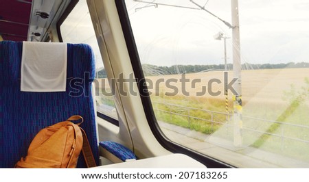 Train seat near the window with a lonely travel backpack