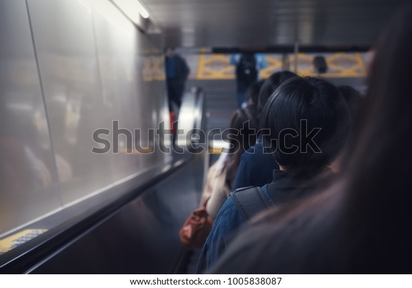 At the\
train station during rush hour: Asian people standing at the right\
side of elevator and keep the left side for people who hurry, show\
the discipline when use public\
infrastructure