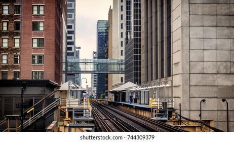 Train Station on Elevated tracks within buildings at the Loop, Glass and Steel bridge between buildings Chicago City Center - Soft Warm Artistic Effect - Chicago, Illinois, USA
