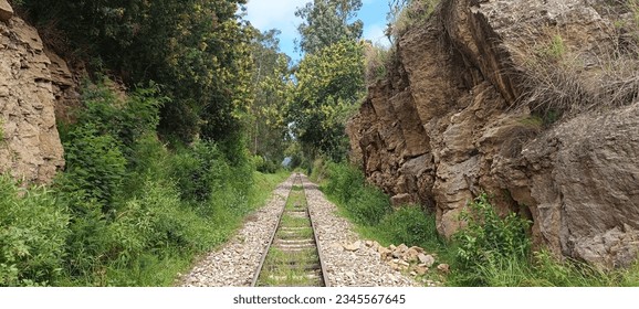 Train track advancing between rocks towards infinity.