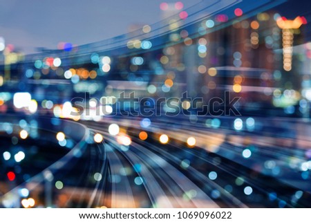 Train track curved over blurred bokeh city business downtown light night view, abstract background