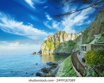 Train track is passing by a colorful Italian village overlooking the ligurian sea on a beautiful sunny day with blue skies and white clouds, in Cinque Terre National park - Powered by Shutterstock