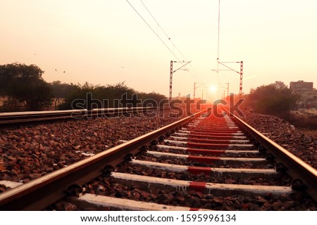 Train track perspective view during sunset time. The track on a railway or railroad, also known as the permanent way, is the structure consisting of the rails, fasteners, railroad ties and ballast or 