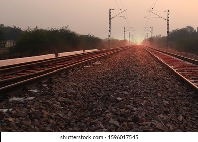 Train track perspective view over sunset sky outdoors.      