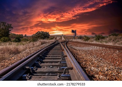 train tracks crossing at sunset under a bridge - Powered by Shutterstock