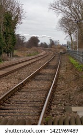 Train Tracks Leading Into The Distance With Factory In The Background