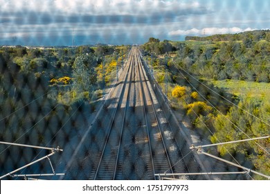 Train Tracks Located Between The Mountains, Seen From The Bridge Through The Gate. Depth And Path Concept.