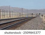 Train tracks looking down the line at a headlight in the distance