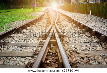 train tracks on gravel, two of railways tracks merge with sunset background, concept of success 