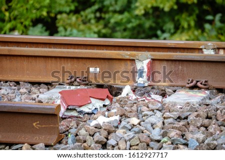 Train tracks recently joined using thermite welding. The sand mould used in the weld is laying beside the railway tracks.