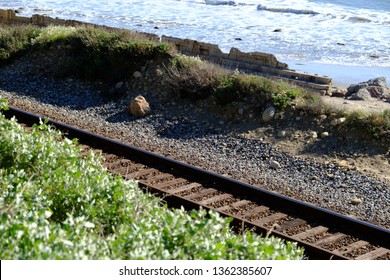 Train tracks running parallel to the seemingly endless ocean