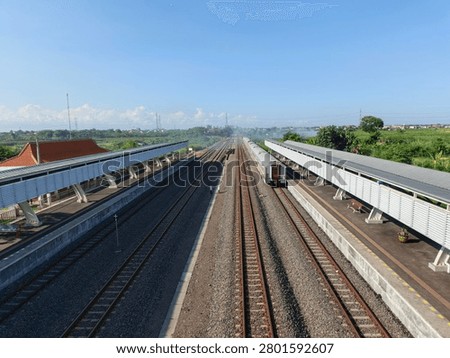 Train Tracks and Symmetrical Platform Architecture Under Blue Sky