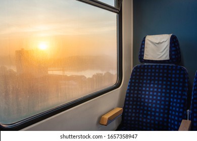 Train Travel Context With German Train Interior, A Comfortable Blue Seat And Sunrise Scenery On Train Window, Near Hamburg, Germany. Vacation Travel.