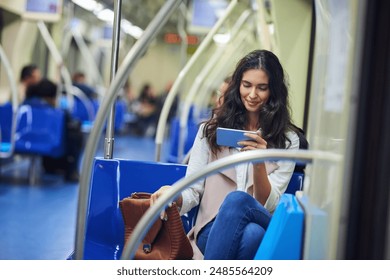 Train, travel and woman with phone for watching videos on journey, commute and passenger on metro. Public transport, railway and person on smartphone for social media, internet and website on subway - Powered by Shutterstock