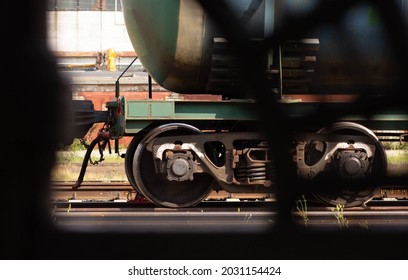 Train wheel through black fence as frame on railroad
