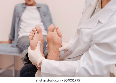 Trained competent specialist checking patients soles - Powered by Shutterstock