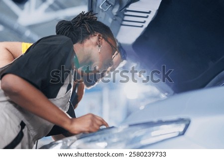 Trained engineers using oil extractor tool to change old car transmission fluid with new one in repair shop. Garage workspace specialists using professional equipment to do vehicle maintenance