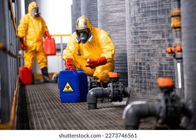 Trained factory workers carefully handling toxic and dangerous biohazardous waste in chemicals factory. - Shutterstock ID 2273746561