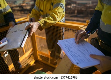 Trained supervisor safety auditor competent reviewing document issued sign approvals of working at height permit JSA risk assessment on site prior to performing high risk work mining construction site - Shutterstock ID 1379418986