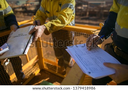 Trained supervisor safety auditor competent reviewing document issued sign approvals of working at height permit JSA risk assessment on site prior to performing high risk work mining construction site
