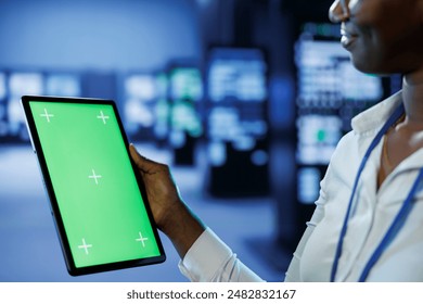 Trained technician in server room using mockup tablet to future proof network from downtimes and unexpected system failures. Expert with isolated screen device ensuring increased data security - Powered by Shutterstock - Get 15% off with code: PIKWIZARD15