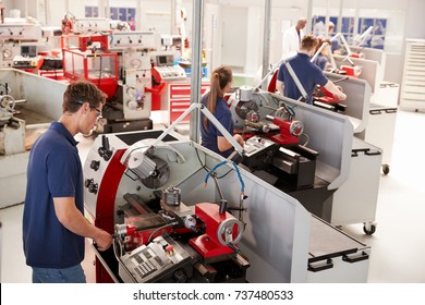 Trainee Engineers Operating Equipment In A Small Factory