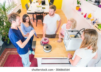 Trainees And Designers Meeting Around A 3D Printer, Discussing Novel Technologies And New Product Ideas And Developments Using 3D Printing Technology