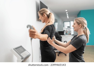 trainer assisting a client on a body composition medical scale for a Inbody test in a gym, both smiling. - Powered by Shutterstock