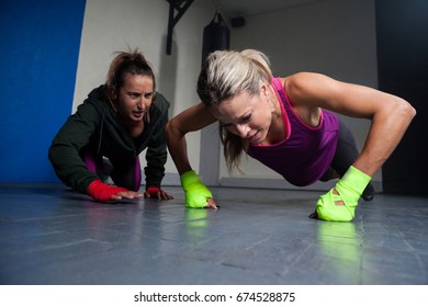 Trainer assisting woman in exercise at fitness studio - Powered by Shutterstock