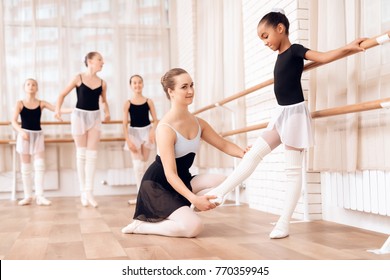 The Trainer Of The Ballet School Helps Young Ballerinas Perform Different Choreographic Exercises. They Rehearse In The Ballet Class. The Teacher Communicates With The Children.
