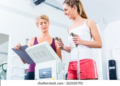 Trainer With Body Fat Scale In Gym Measuring Woman