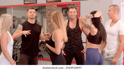 The trainer gives information to the students before training in the gym Group interactions occurring gym environment, highlighting both culture active social engagement  - Powered by Shutterstock