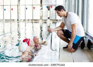 Trainer with stop-watch talking to his team in front and explaining them what they are going to do next - Powered by Shutterstock