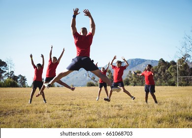 Trainer Training Kids In The Boot Camp On A Sunny Day