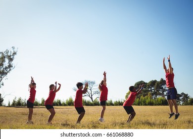 Trainer training kids in the boot camp on a sunny day - Powered by Shutterstock